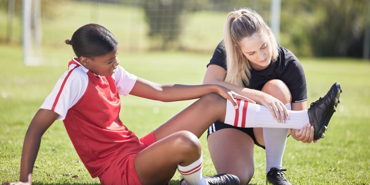 Soccer, sports and injury of a female player suffering with sore leg, foot or ankle on the field. P